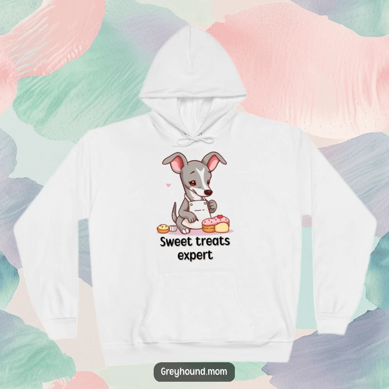 Funny Greyhound baker hoodie featuring a slender dog wearing an apron, delicately decorating a tiny pastry with artistic precision.